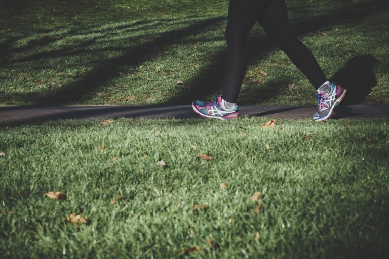 A person walking on a scenic path surrounded by nature, promoting fitness and well-being.