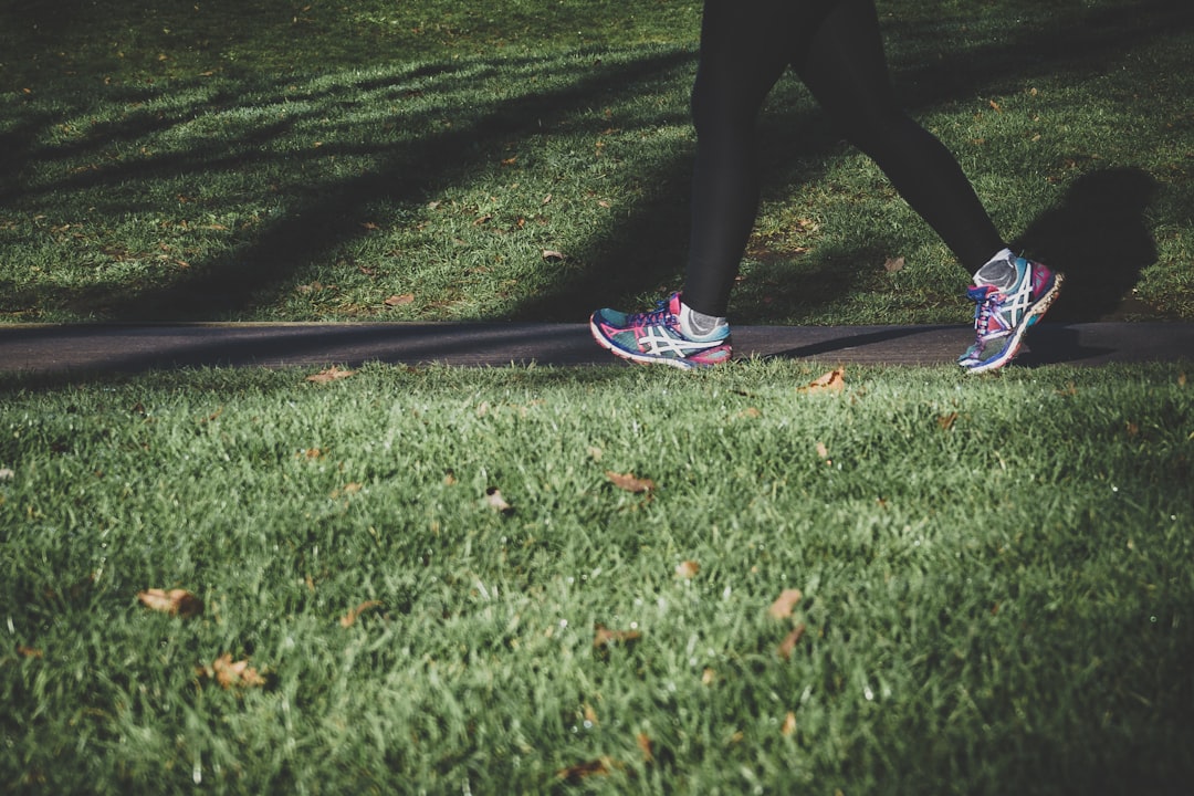 A person walking on a scenic path surrounded by nature, promoting fitness and well-being.