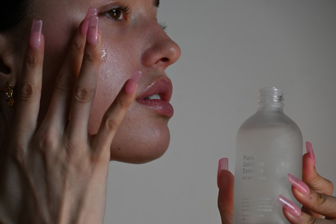A flat lay of various skincare products arranged in the order of application, including cleansers, serums, and moisturizers, with a soft morning or evening light.